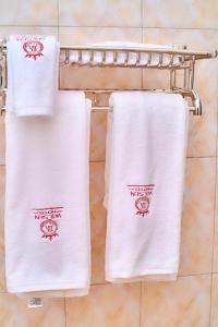 three towels on a towel rack in a bathroom at Wilsen Hotel Nansana in Kampala
