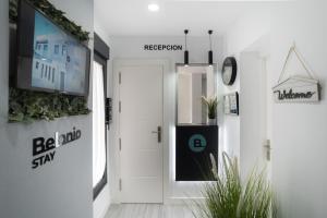 a hallway with a door and a tv on a wall at Stay Belonio in Málaga