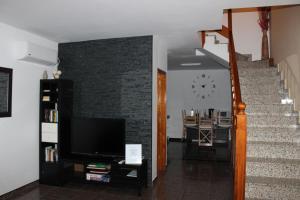a living room with a tv and a brick wall at LA ORILLA BEACH HOUSE in La Lajita