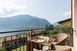 a table on a balcony with a view of the water at Vista Azzurra in Sala Comacina