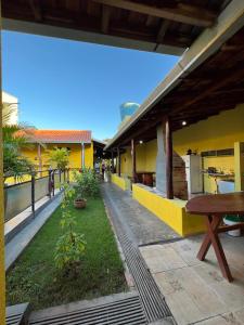 a courtyard of a house with a bench and a table at Pousada Rio Bonito in Bonito