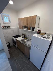 a kitchen with a white refrigerator and a sink at A&S in Ljubuški