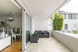 sala de estar y comedor de planta abierta con puertas correderas de cristal en Luxury poolside view apartment, en Funchal
