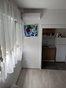 a living room with white curtains and a kitchen at A&S in Ljubuški +12 photos