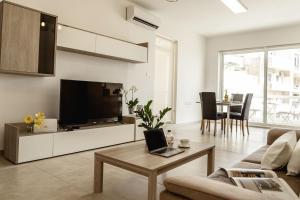 a living room with a couch and a tv at Beautiful 2 bed in center Sliema near beach in Sliema
