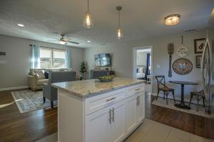 a kitchen and living room with a counter and a table at Ranch Style Home & Plenty Of BKYD Space Near KSU in Marietta
