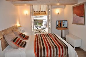 une chambre avec un grand lit et une télévision dans l'établissement les Chambres Tropéziennes, à Sanary-sur-Mer