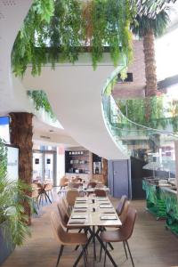 a restaurant with tables and chairs and plants at SoBlue Hôtel in Antibes