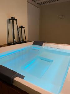 a swimming pool with blue lights in a room at SETTANNI Sea Suites in Polignano a Mare