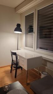 Studio flat in the heart of Zug, ideal for solo travellers في زوغ: مكتب وكرسي في غرفة مع نافذة
