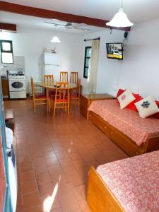 a room with two beds and a table and a kitchen at Castillo Del Lago - Carlos Paz - D07 in Villa Carlos Paz