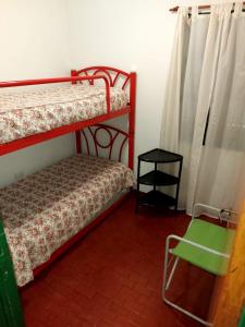 1 dormitorio con 2 literas y una silla verde en Castillo Del Lago - Carlos Paz - D07 en Villa Carlos Paz