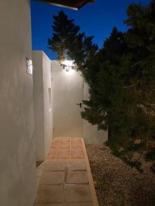 a hallway of a white building with a tree at Paradise, Porto Saler ET7104 in La Savina