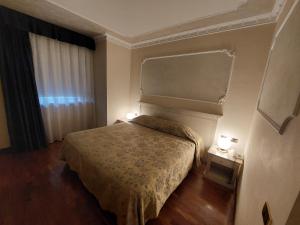 ロッカ・サン・ジョヴァンニにあるHotel Villa Mediciのベッド1台と照明2つが備わるホテルルームです。