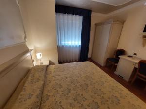 ロッカ・サン・ジョヴァンニにあるHotel Villa Mediciのベッドルーム1室(ベッド1台、窓、デスク付)