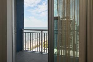 a room with a balcony with a view of the ocean at Residence Inn by Marriott Myrtle Beach Oceanfront in Myrtle Beach