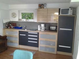 eine kleine Küche mit einer Spüle und einer Mikrowelle in der Unterkunft Ferienwohnung am Wald in Erbach