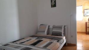 a bed with pillows on it in a room at Zowanj 1 - Logement avec vue panoramique in Le Robert