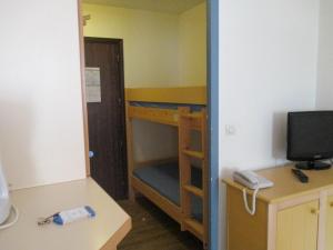 サン・ラファエルにあるPromenade des Bains Apartmentの二段ベッド、デスク、テレビが備わる客室です。