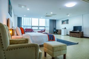 a hotel room with a bed and a chair and a tv at The View Hotel Restaurant & Sky Lounge in Freetown