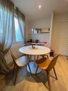 einen Tisch und Stühle im Wohnzimmer mit einem Tisch in der Unterkunft Apparte/Hotel de Luxe in Melun