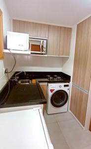 a small kitchen with a stove and a microwave at Chalé esquina da CATEDRAL de Canela in Canela