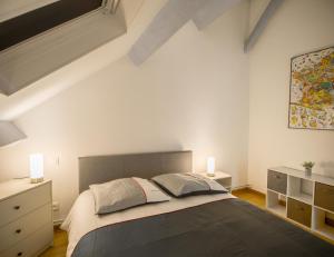 una camera con un grande letto e due lampade di Le Duplex Troyen - 5 min Hypercentre - Ideal Groupe - Parking Gratuit a Troyes