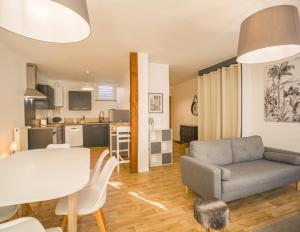 a living room with a couch and a table at Le Duplex Troyen - 5 min Hypercentre - Ideal Groupe - Parking Gratuit in Troyes