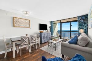 uma sala de estar com um sofá e uma mesa e uma sala de jantar em Beautiful Direct Ocean Front North Myrtle Condo em Myrtle Beach