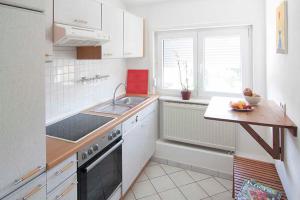 een keuken met een wastafel en een fornuis top oven bij Ferienwohnung Waldblick in Bad König