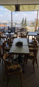 eine Gruppe von Tischen und Stühlen mit einem Schirm in der Unterkunft Moab Hotel & Restaurant in Madaba