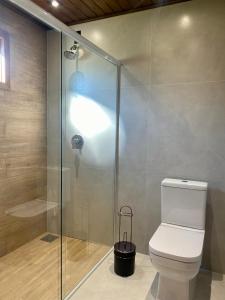 a bathroom with a toilet and a glass shower at Mirador da Montanha in Praia Grande