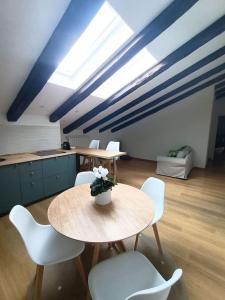 Habitación con mesa, sillas y cocina. en Loving My Rooms 1 - Deliziosa Mansarda in Centro, en Gorizia