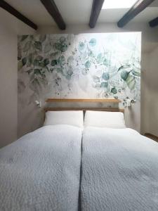 a bedroom with a bed with a flower mural on the wall at Loving My Rooms 1 - Deliziosa Mansarda in Centro in Gorizia