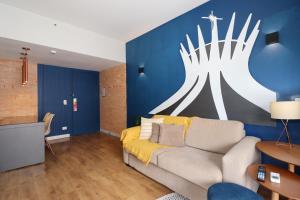 a living room with a couch and a blue wall at Flat Centro de Brasilia in Brasilia