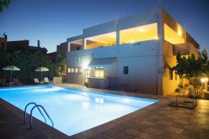 een zwembad voor een huis 's nachts bij Domenica Apartments in Rethimnon