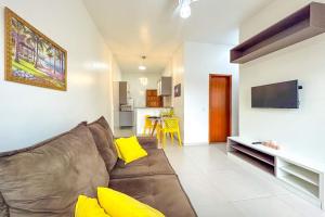 a living room with a brown couch and yellow pillows at Casa c piscina em frente ao mar-Barra de Sao Joao in Casimiro de Abreu