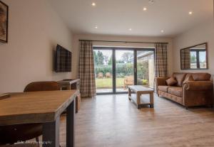 sala de estar con sofá y mesa en Molehill Cottage - New 2023 - EV Charger - Pets, en Beverley