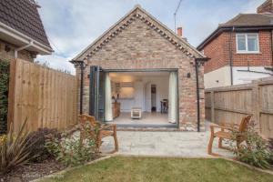 a brick house with a door open to a backyard at Molehill Cottage - New 2023 - EV Charger - Pets in Beverley