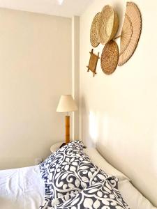 a bedroom with a bed and straw hats on the wall at Pousada OCEAN in Saquarema