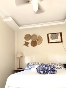 Pousada OCEAN في ساكاريما: غرفة نوم مع سرير وقبعات على الحائط