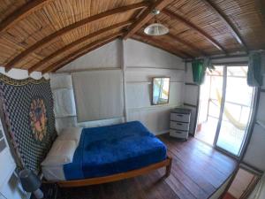 1 dormitorio con 1 cama azul en una habitación en La Gondola, en Montañita