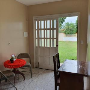 a dining room with a table and a sliding glass door at Casa Bouganville in Novo Airão