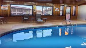 a swimming pool in a hotel with chairs and tables at Goulding's Lodge in Monument Valley