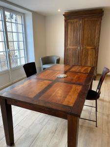 una gran mesa de madera en una habitación con sillas en Le Saint-Hilaire, en Saint-Hilaire-de-Brens