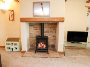 sala de estar con chimenea y TV en Rivendell en Holmfirth