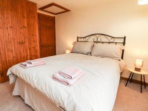a bedroom with a bed with two towels on it at Rivendell in Holmfirth