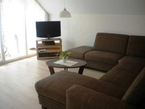 sala de estar con sofá y mesa con TV en Ferienhof Knoll, en Lindenfels