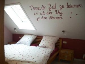 - une chambre dotée d'un lit avec une citation sur le mur dans l'établissement Ferienhof Knoll, à Lindenfels