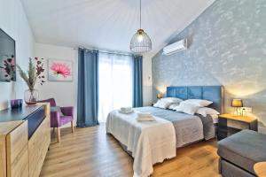 ein Schlafzimmer mit einem Bett, einem TV und einem Sofa in der Unterkunft Apartments Bobinac in Senj